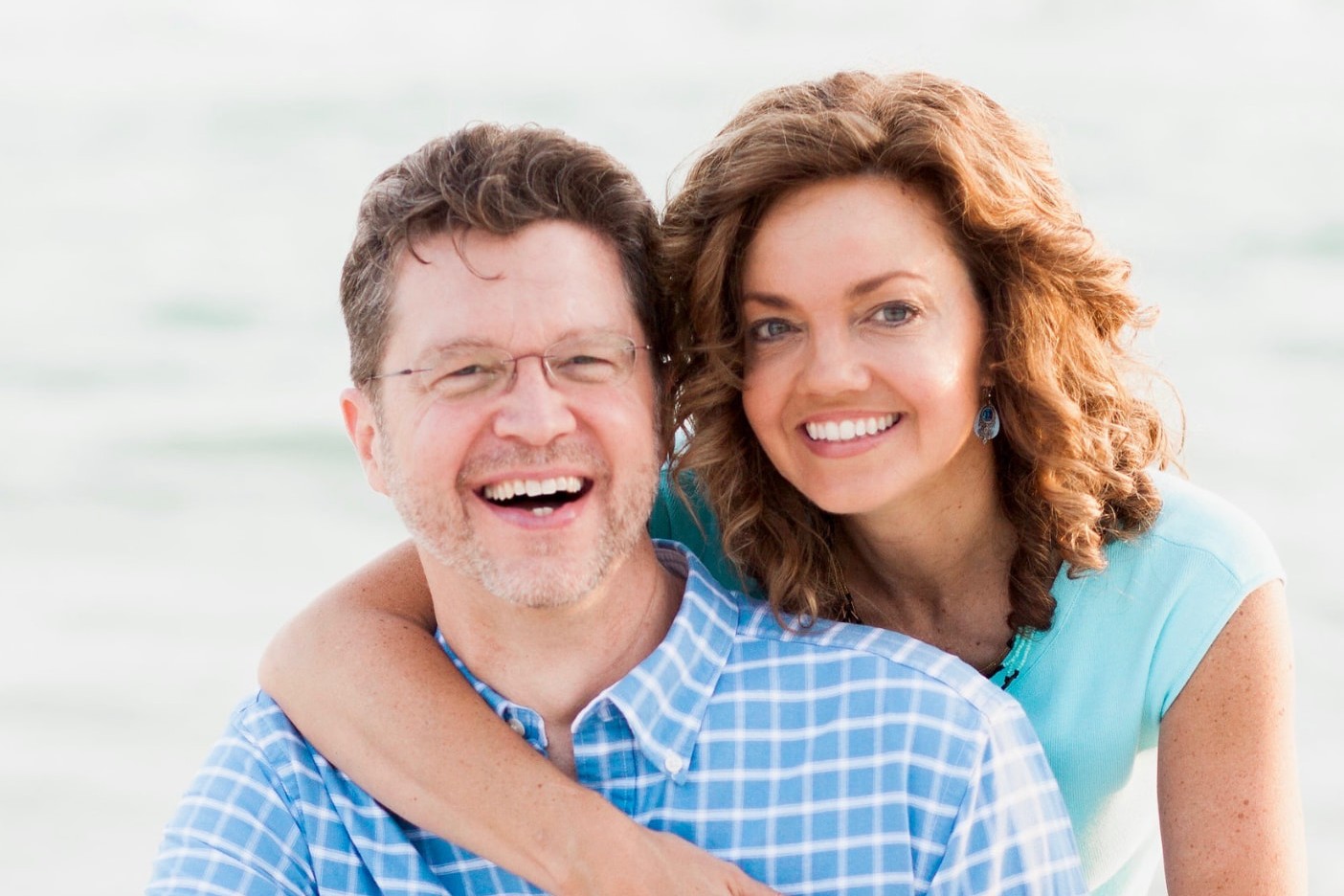 Chris and Rachel McCluskey laughing together on the beach